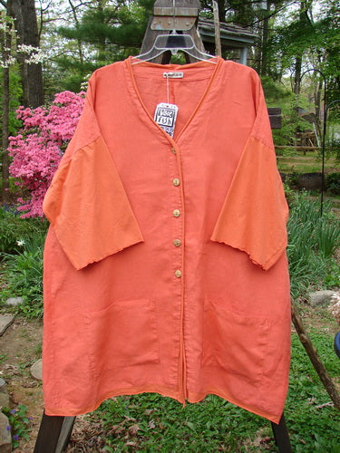 Barclay NWT Linen Cotton Sleeve Pocket Cardigan Contrast Unpainted Clementine Size 2 displayed on a swinger, highlighting wooden-like buttons, upward curved hemlines, deeper V neckline, and drop-front squared pockets.