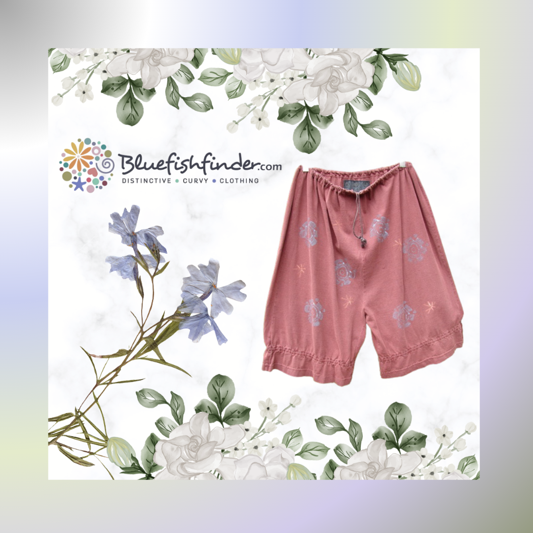A pair of shorts from the Summer collection of 1991 is displayed with a floral design background in a pastel gradient Frame. The Knicker has gathered lowers and a drawcord waistline. They are a mid length short with a vintage bloomer vibe. 