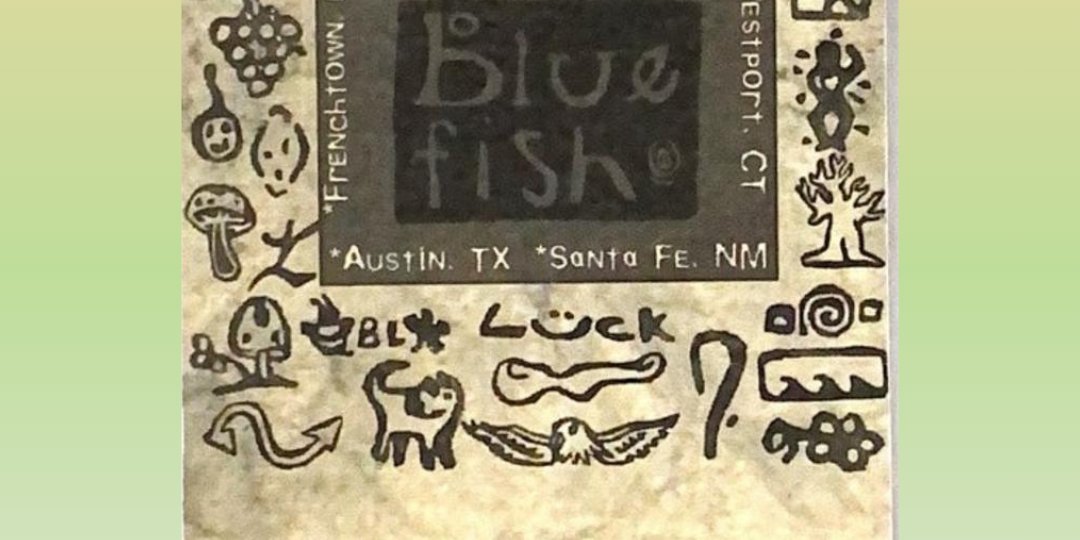 A clothing hang tag with a black square featuring artist stamps with store location text from the Blue Fish Clothing Company