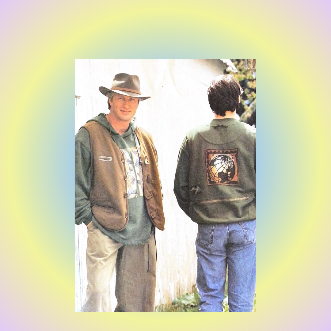 A 1998 Fall example, featuring a man standing next to another man, wearing a vest and a green sweatshirt with a picture of the earth on the back. The image also includes a close-up of a globe and a person wearing a hat and jacket and huge center art.