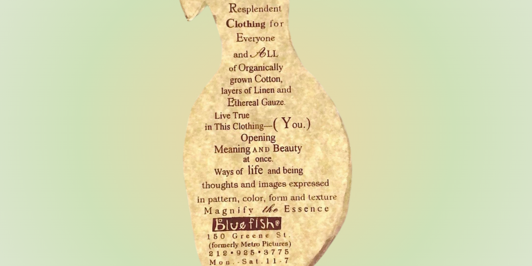A close-up of a uniquely shaped hang tag depicting a woman's short sleeved long dress. Text surrounds the center in a red brown color on a pale sandy yellow background. The tags appears to float off the backdrop of pastel green.