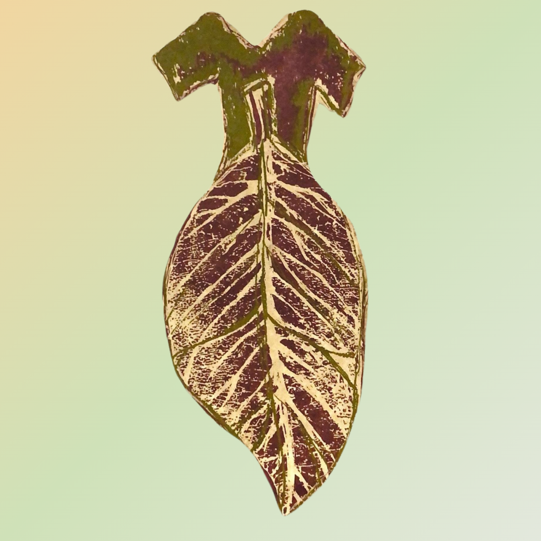 A close-up of a uniquely shaped hang tag depicting a woman's short sleeved long dress painted in a leaf pattern. Text surrounds the center in a red brown color on a pale sandy yellow background. The tags appears to float off the backdrop of pastel green.