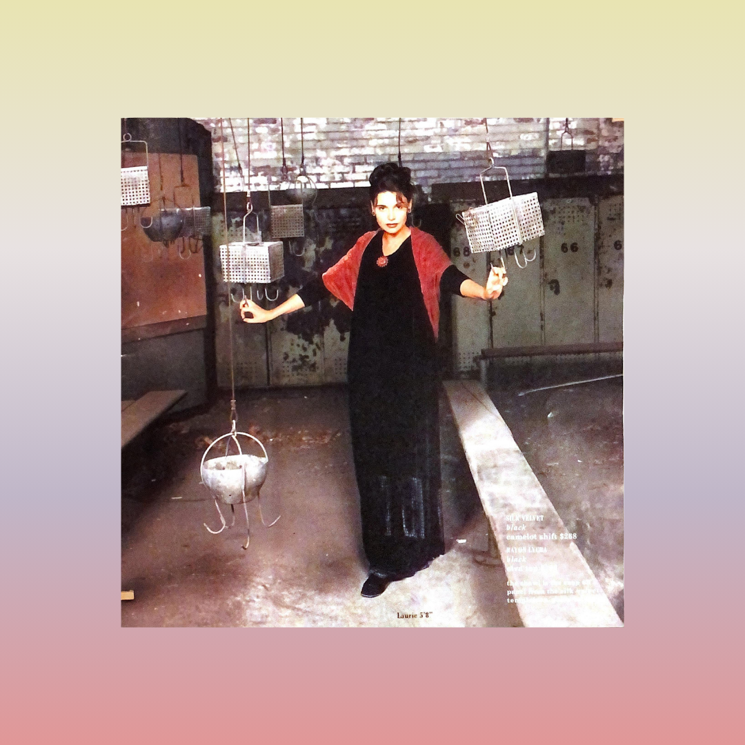 A woman standing with baskets, wearing a black dress and bright red velvet accent piece around her shoulders. From the holiday silk velvet collection of 2000