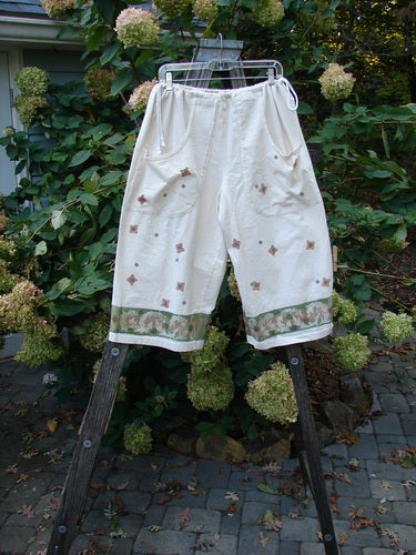 1993 Garden Pant Wind Flower Tea Dye Size 1 displayed on a rack, featuring deep pockets, side ties with metal grommets, and a vintage floral design, emphasizing its unique crop shape.