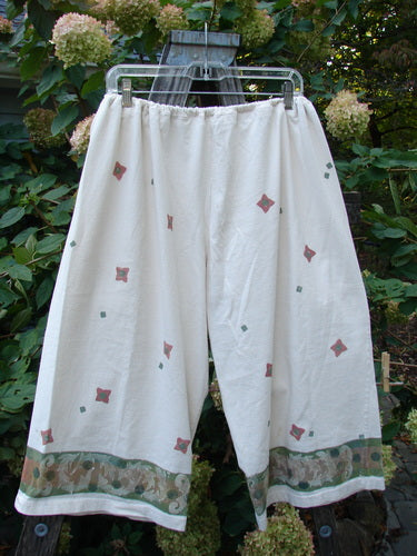 1993 Garden Pant Wind Flower Tea Dye Size 1 displayed on a clothes rack, featuring side ties with metal grommets and deep bushel pockets, showcasing its unique vintage wind flower theme design.