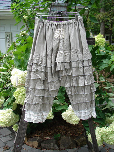 Magnolia Pearl Silk Voile Lace Alice in Wonderland Bloomer Silver Moss OSFA on a rack, featuring delicate ruffles, amidst flowers.