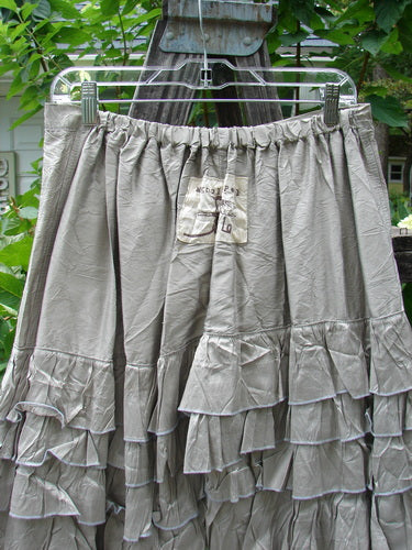 Magnolia Pearl Silk Voile Lace Alice in Wonderland Bloomer Silver Moss OSFA skirt hanging on a clothes rack, showcasing delicate fabric and intricate lace details.