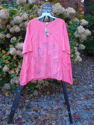 Barclay NWT Batiste Cross Over Urchin Dress, featuring a pink shirt on a swinger, plant, and a table with pink sheet on the ground.