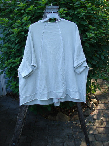 Barclay NWT Photogram Open Front Jacket Unpainted Dew OSFA with wide three-quarter sleeves, angular hem, dolman shoulders, and sectional panels, displayed on a clothes rack, highlighting its relaxed, flowing silhouette.