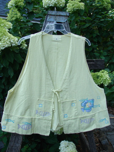 1999 Fishing Vest Fish School Citron Size 0: A yellow vest with fish painted on it, featuring a tie front, squared pockets, deeper arm openings, an A-line flare, and a special rear pocket.