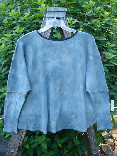 Barclay NWT Thermal Crop Top Love Dove Mottled Top Lake OSFA, showcasing a waffle-textured fabric with drop shoulders, fitted lower sleeves, and a unique A-line flair, displayed on an outdoor swinger.