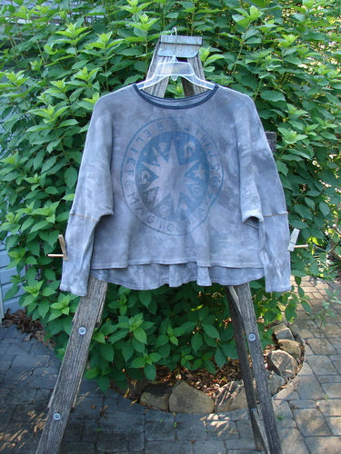 Barclay Thermal Crop Top Belief Spirit Mottled Plum River OSFA displayed on a wooden stand, showcasing its scooped neckline, A-line flair, and distinctive vintage theme paint with contrasting stitchery.