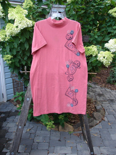 1996 Midway Dress Abstract Oriole Size 1, featuring a ribbed mock standup neck, drop shoulders, and an abstract floral pattern, displayed on a wooden rack, made from mid-weight organic cotton in excellent condition.