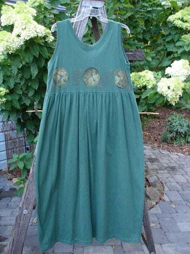 1997 Alcove Jumper Time Verdigris Altered Size 1 hanging on a clothesline, featuring a wide sweeping hemline, empire waist seam, and clock-themed paint details, showcasing a slimmer fit with alterations.