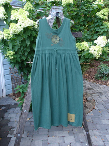 1997 Alcove Jumper Time Verdigris Altered Size 1 displayed on a clothes rack, featuring a wide sweeping hemline, empire waist seam, and a drawcord back, accented with primitive theme paint.