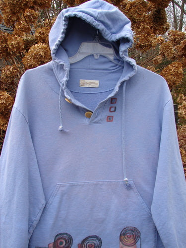 1999 Two Button Pullover Hooded Festive Moon Skylark Size L: A blue sweatshirt with a hood, featuring a heavier weighted French terry fabric. It has a versatile A-line shape, two larger front drop pockets, and a super cozy hood with drawstring.