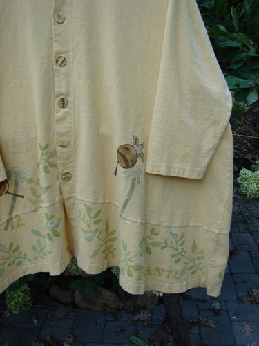 1998 Botanicals Orchard Jacket Vine Pod Sundial Size 2: Close-up of a vintage mid-weight organic cotton jacket featuring a detailed vine and pod pattern, button-down style, wide-banded A-line hem, and signature Blue Fish patch.