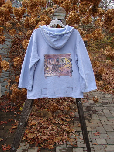 1999 Two Button Pullover Hooded Festive Moon Skylark Size L: A blue hooded sweatshirt with a festive moon theme, two front pockets, and a cozy drawstring hood.