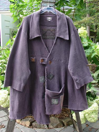 2000 PMU Celtic Moss Highlander Coat Aubergine Size 1, featuring oversized front buttons, multiple patches, an empire waistline, and a super front lower drop pocket, displayed on a swinger.