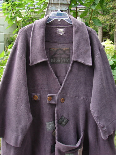 2000 PMU Celtic Moss Highlander Coat Aubergine Size 1 displayed on a hanger, featuring oversized front buttons, a large collar, multiple patches, and a plush, dense winter weight fabric.