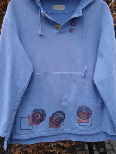 1999 Two Button Pullover Hooded Festive Moon Skylark Size L: A blue sweatshirt with a design on it, featuring a hood, two front pockets, and a three-button front.