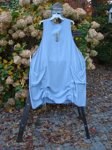 Barclay NWT Twill Joyous Jumper, size 2, on a rack with blue dress, apron, and sheet. Features shallow neckline, drop front pockets, and deep arm openings. Made from organic cotton twill.