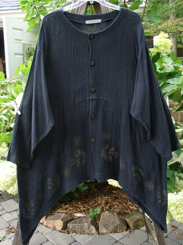 1998 Limited Edition Gauze Orchard Jacket in Raven, displayed on a clothes rack, showcasing its wide banded A-line shape, rounded button front, and unique curved inset seams with nature-themed paint.