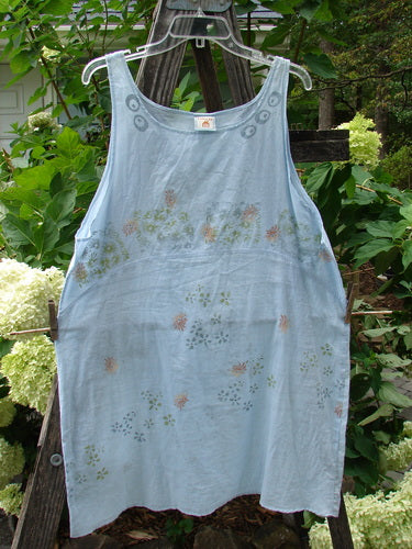 Barclay Batiste Short Tunic Tank Continuous Tiny Floral Birdsong Size 1 displayed on a clothesline, featuring a rounded neckline, widening lower, deeper arm openings, and a downward curved empire waist seam.