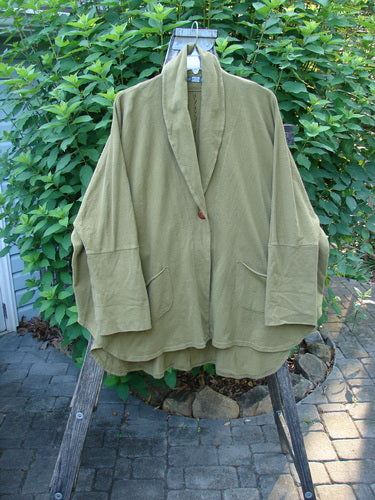 Barclay Reprocessed Golden Hour Deco Jacket Rear Folly Peapod OSFA displayed on a rack, showcasing its dense cotton texture, single button closure, and unique V-shaped neckline with oversized pockets.