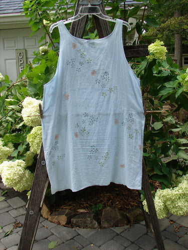 Barclay Batiste Short Tunic Tank Continuous Tiny Floral Birdsong Size 1 displayed on a wooden ladder, showcasing its rounded neckline, wider lower, and seamless back with a downward curved empire waist seam.