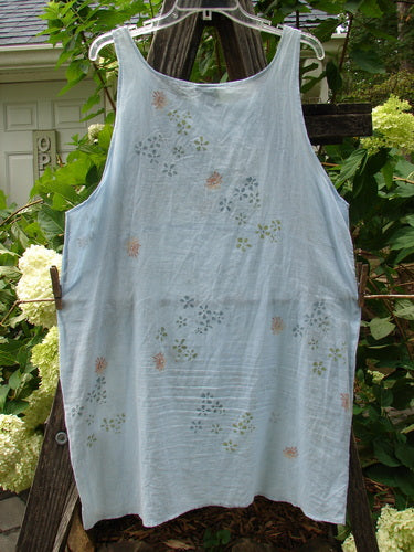 Barclay Batiste Short Tunic Tank in Birdsong, featuring a rounded neckline, seamless back, and a continuous tiny floral pattern, hanging on a clothesline outdoors.