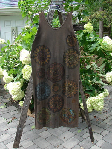 1992 Holiday Sleeveless Column Dress Giant Metallics Grey Sand OSFA displayed on a wooden ladder, showcasing its scooped neckline, straight long fall, and holiday-themed metallic pinwheel design.