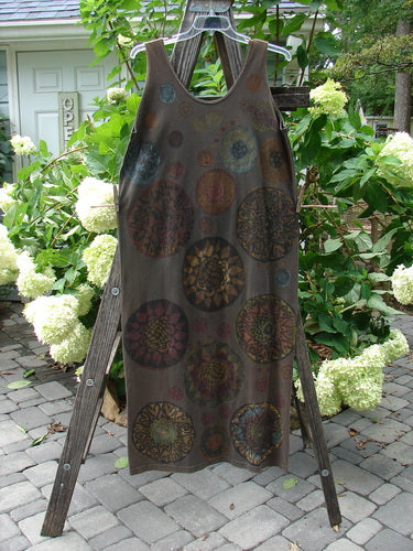 1992 Holiday Sleeveless Column Dress Giant Metallics Grey Sand OSFA displayed on a wooden ladder, showcasing its scooped neckline, straight long flow, and giant metallic pinwheel theme.