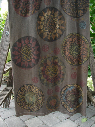 1992 Holiday Sleeveless Column Dress in Grey Sand displaying a giant metallic pinwheel pattern, scooped neckline, straight fall, and not too deep arm openings, hanging on a rack.