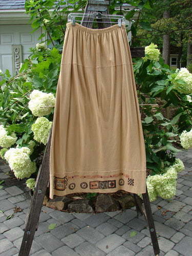 1998 Scrabble Skirt Games Bamboo Size 2 displayed on a rack outdoors, showcasing its flat folded front waistline, elastic rear, horizontal panels, and classical games theme paint.