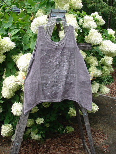 Barclay Linen Altoll Top Wing Stats Rose Quartz Size 0 in soft rose quartz linen, a sleeveless swing top with a V-neckline, wide shoulder straps, and a gently flared hem, hanging on a wooden ladder amid white hydrangeas.