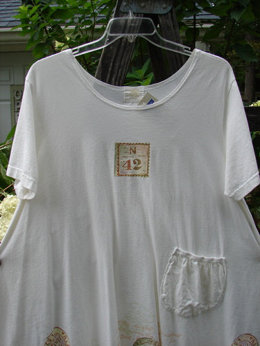 White 2000 NWT June Straight Duo Postage Size 2 featuring a rounded neckline, front pouch pocket with elastic top, and postage theme paint, displayed on a hanger.