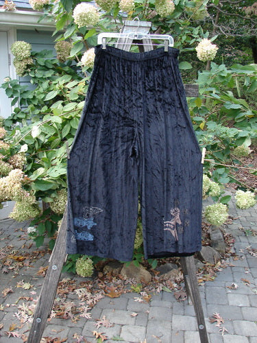 1997 Velvet Cosmos Pant Primitive Ram Obsidian Size 2 displayed on a clothes rack, showcasing its flowy design with a full two-inch elastic waistband and suggestively painted lowers.