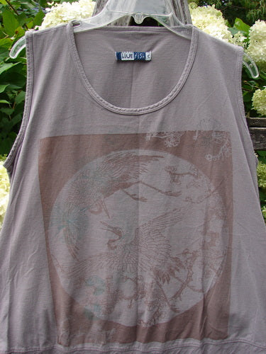 Barclay Flutter Bottom Tank Top Moon Bird in stone plum, size 2, with a sleeveless scoop neck and flutter hem. The soft heathered knit shows a faded moon-and-bird graphic across the front, hanging on a clear hanger against leafy greenery.