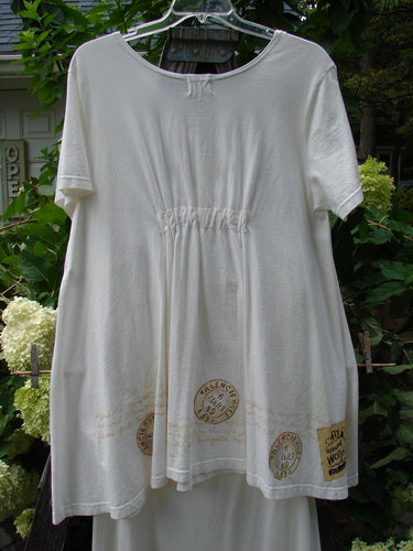 2000 NWT June Straight Duo Postage White Size 2: A white dress with stamp prints featuring a rounded neckline, front pouch pocket, and matching straight skirt with an elastic waistband and hem detailing.