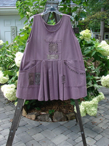 1995 Denim Invention Smock Modern Lolly Flower Heliotrope OSFA on wooden rack, features front and side pockets with metal rivets, front pleats, and back painted tunnel pocket.