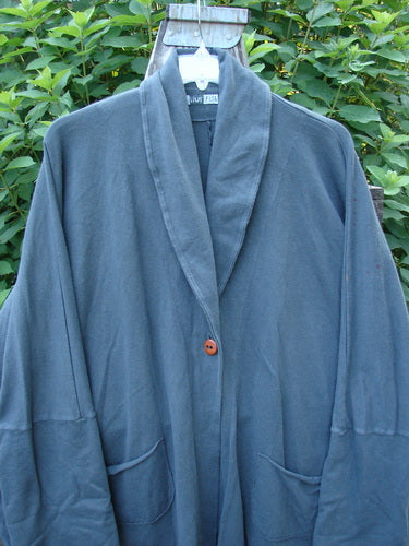 Barclay Reprocessed Golden Hour Deco Jacket in Black Olive, showcasing a dense cotton fabric, single button closure, dolman shoulders, and diagonal pockets, seen on a swinger.