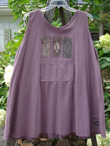 Purple 1995 Denim Invention Smock Modern Lolly Flower Heliotrope OSFA hanging on a clothesline, showcasing front pleats, bib pocket, scooped side pockets, and wide A-line shape with a back tunnel pocket.