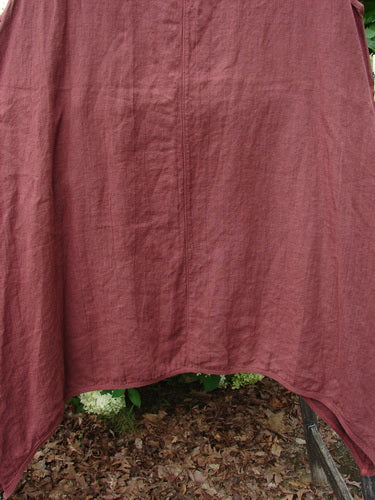 Barclay Summercloth Round Pocket Pinafore Star Flower Rusty Bucket Size 0 in a muted rusty rose tone, shown as a softly wrinkled fabric garment with a rounded hem and loose drape. The close crop emphasizes the natural texture, vertical seam, and earthy, matte finish.