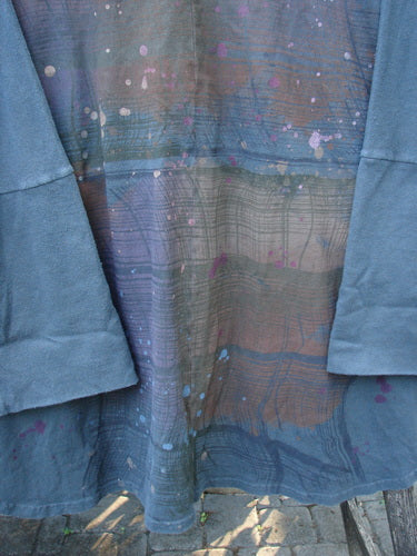 Close-up of the Barclay Reprocessed Golden Hour Deco Jacket Rear Rain Black Olive OSFA, featuring a dense cotton texture, single-button closure, drop dolman shoulders, and oversized diagonal pockets.