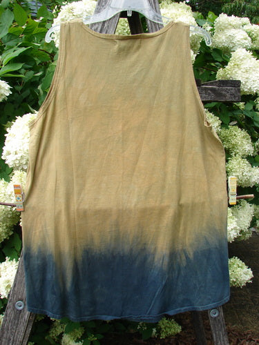 Barclay Round Bottom Tunic Tank Top in Parrot Mottled Golden Sunset, size 0, with a sleeveless, relaxed silhouette and rounded hem. The lightweight fabric fades from muted golden tan to deep mottled blue at the bottom, hanging against leafy greenery.