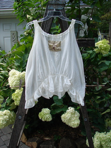 Magnolia Pearl Silken Cotton Voile Ribbon Neck Top White OSFA displayed on a clothes rack; features a delicate ribbon accent, flutter hemline, and tiny pearl buttons for an elegant, vintage look.