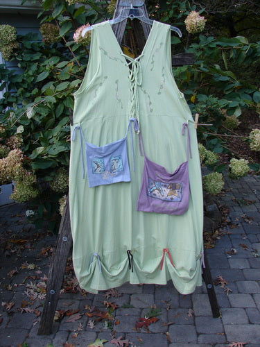 1997 Salt Water Taffy Jumper Sea Life Mellon Size 2 hanging on a clothesline, showcasing its versatile pockets, clear textured buttons, and unique sea life theme paint on organic cotton.