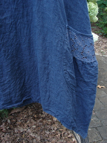Barclay Summercloth Lace Two Pocket Pinafore in unpainted black, size 2, with a loose crinkled fabric drape and a lace-trimmed pocket panel. The dark blue-black textile fills the frame in a close-up view, showing soft folds and a textured, handmade look.