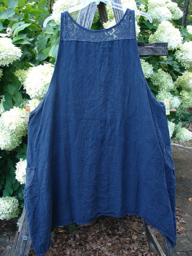 Barclay Summercloth Lace Two Pocket Pinafore in unpainted black, size 2, shown as a sleeveless A-line garment with a lace-trimmed yoke, two side pockets, and softly textured fabric draped on a hanger.